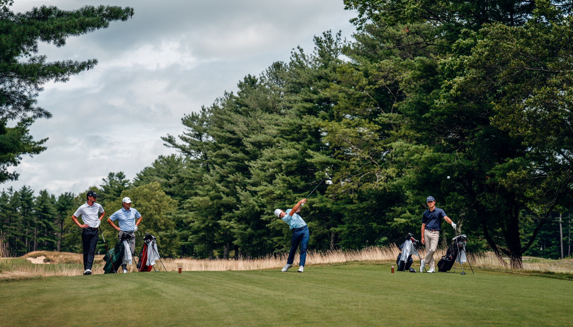 three men on sunny golf course